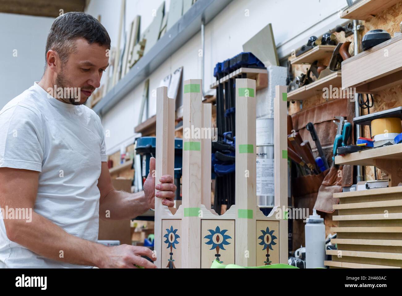 A man is making bespoke furniture in a woodwork showing the