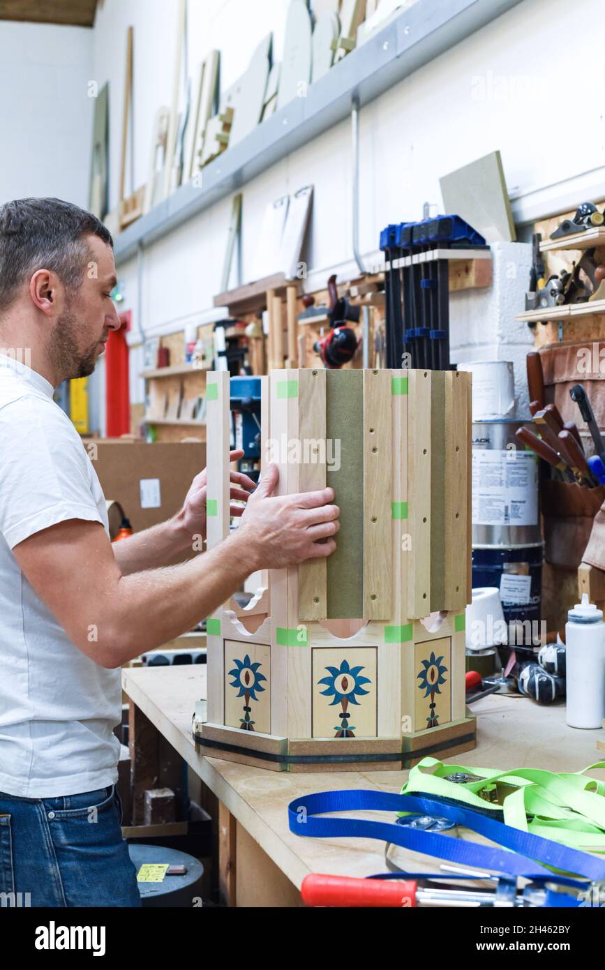 A man is making bespoke furniture in a woodwork showing the construction process Stock