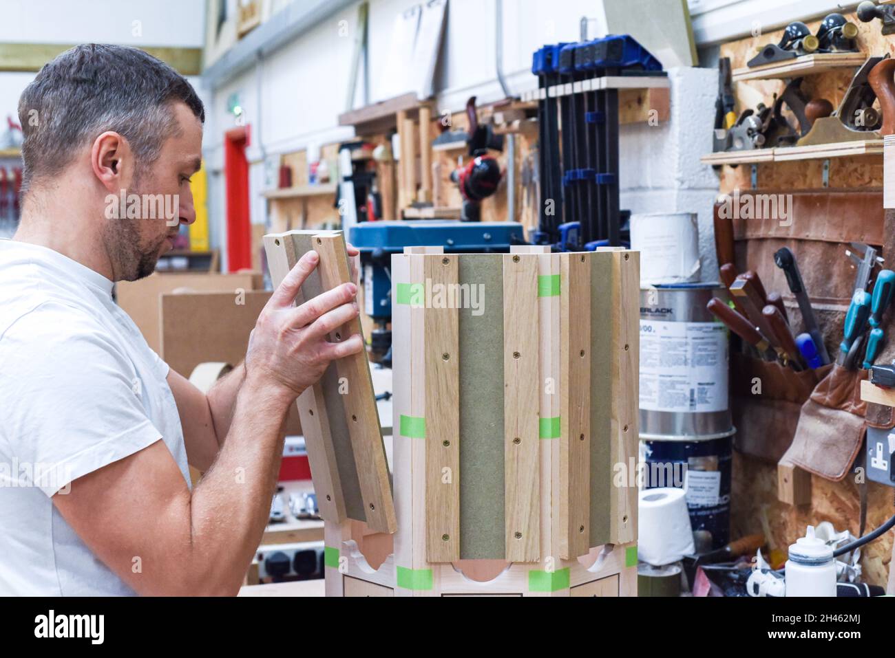 A man is making bespoke furniture in a woodwork showing the construction process Stock