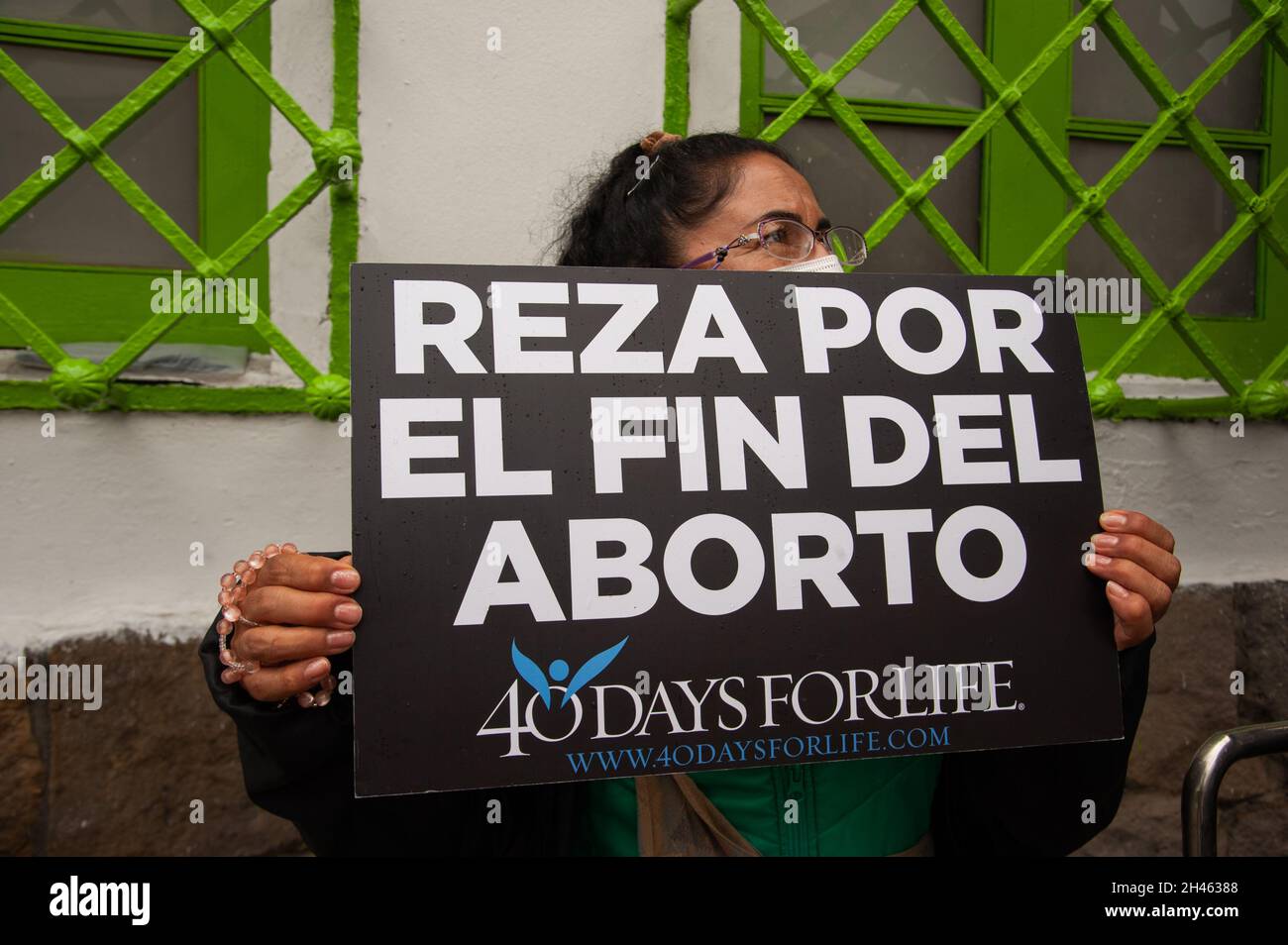 A group of people protests outside Profamilia, family planification health center in Bogota against the practice of abortions in Colombia with a sign that reads 'Pray for abortions to end' on October 30, 2021. Stock Photo
