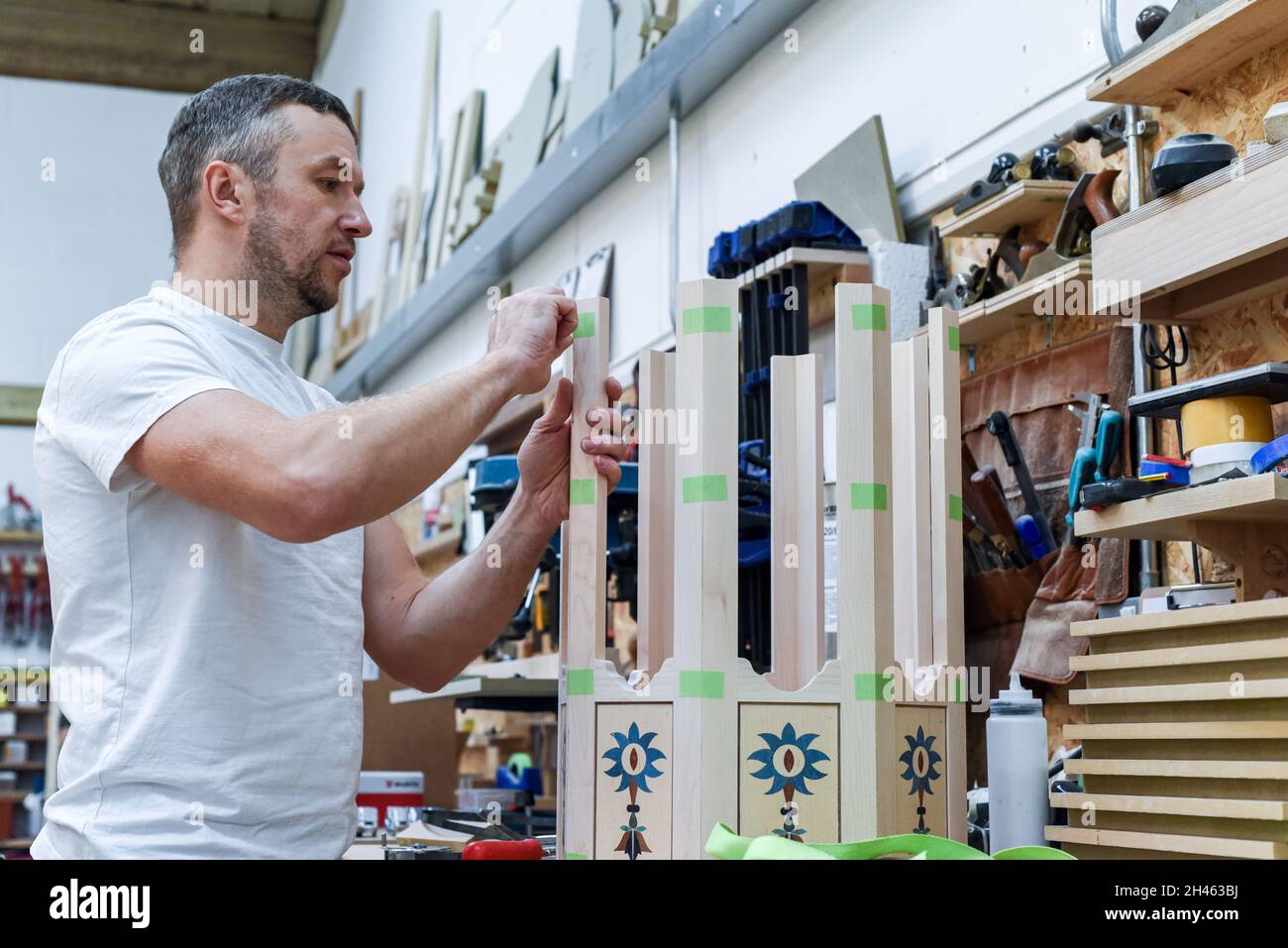 A man is making bespoke furniture in a woodwork showing the construction process Stock