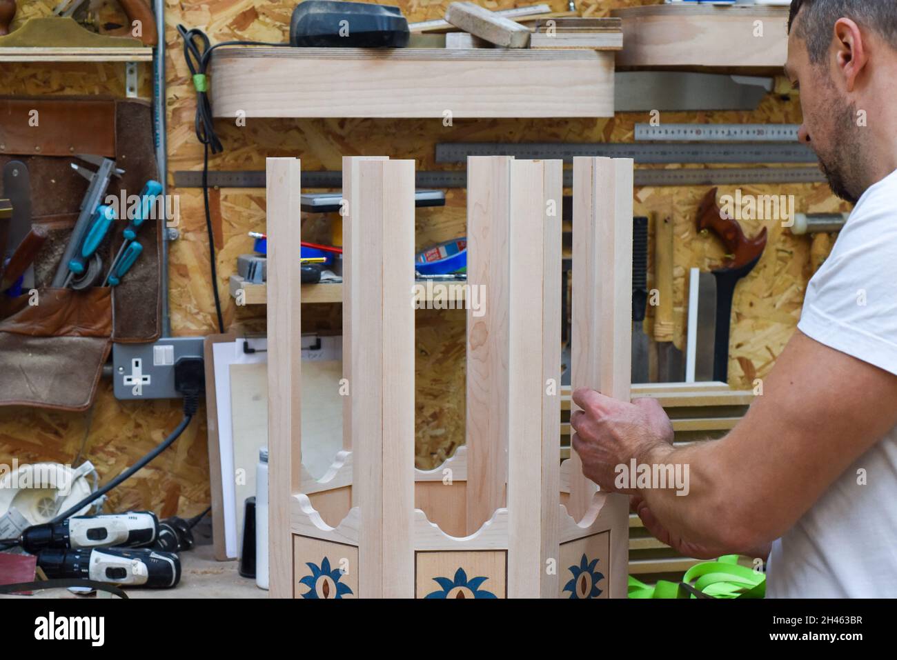 A man is making bespoke furniture in a woodwork showing the construction process Stock