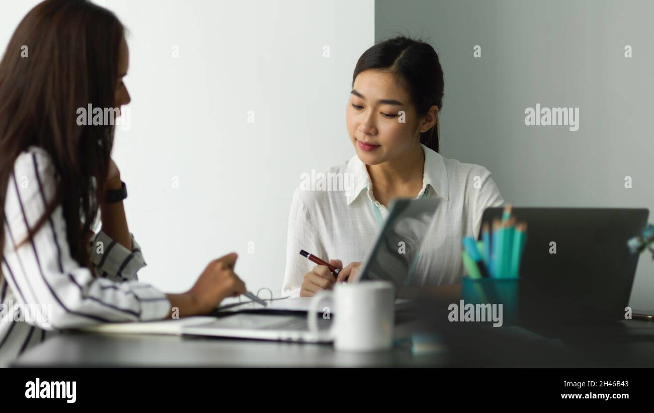 Two of professional female business workers discussing business ...