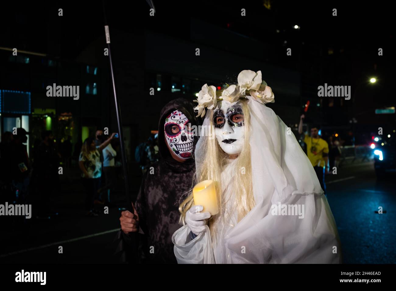 New York City, USA. 31st Oct, 2021. The annual Greenwich Village Halloween parade returned in 2021after a year's suspension because of COVID restrictions. A man wears Mexican-styled death-head makeup, and a woman dresses as a corpse bride and carries a candle. Credit: Ed Lefkowicz/Alamy Live News Stock Photo