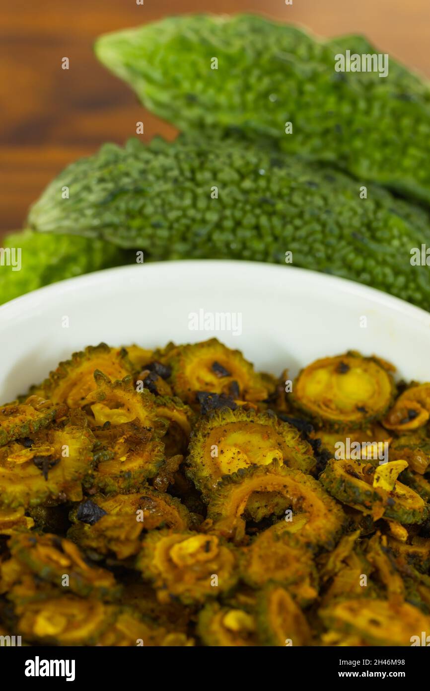 Cooked bitter gourd and raw bitter gourd kept alongside each other