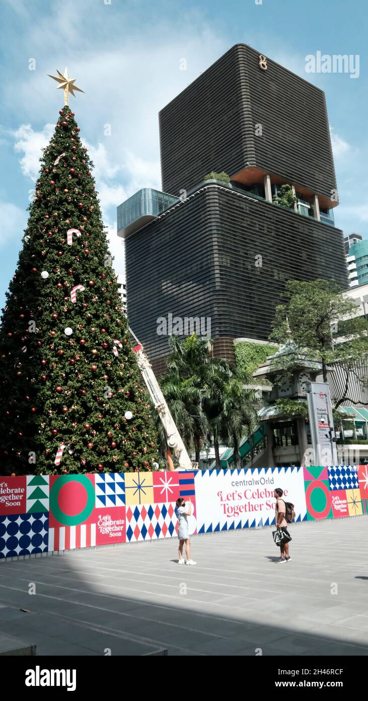 Christmas Tree Long and Tall Going Up Central World Mall Pathum Wan  Bangkok Thailand with President Towers Skyscraper in the Background Stock Photo
