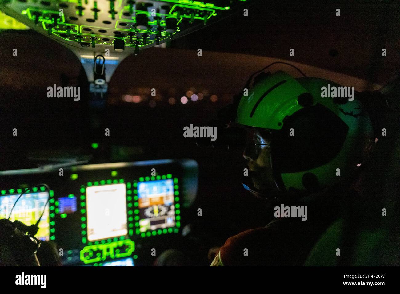 PRODUCTION - 11 October 2021, Baden-Wuerttemberg, Stuttgart: A night vision device illuminates pilot Roy Fleischer's eyes and goggles, while the flight instruments of the rescue helicopter light up around him. The rescue helicopter Christoph 54 is the only one in Baden-Württemberg that also has night flying capacity. The night crew with the two pilots takes over the flying intensive care unit from 6.30 p.m. in the evening until 7 a.m. the following morning. It is stationed at the Villingen-Schwenningen station of the German Air Rescue Service (DRF) and flies missions from there throughout the Stock Photo