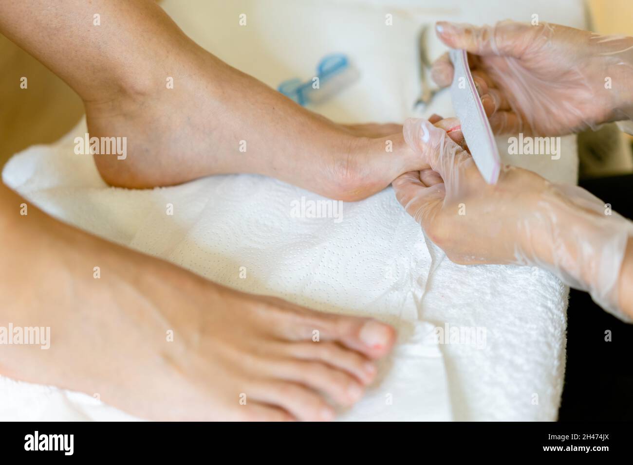 Beautician giving a pedicure painting her client's nails in a beauty centre. Stock Photo