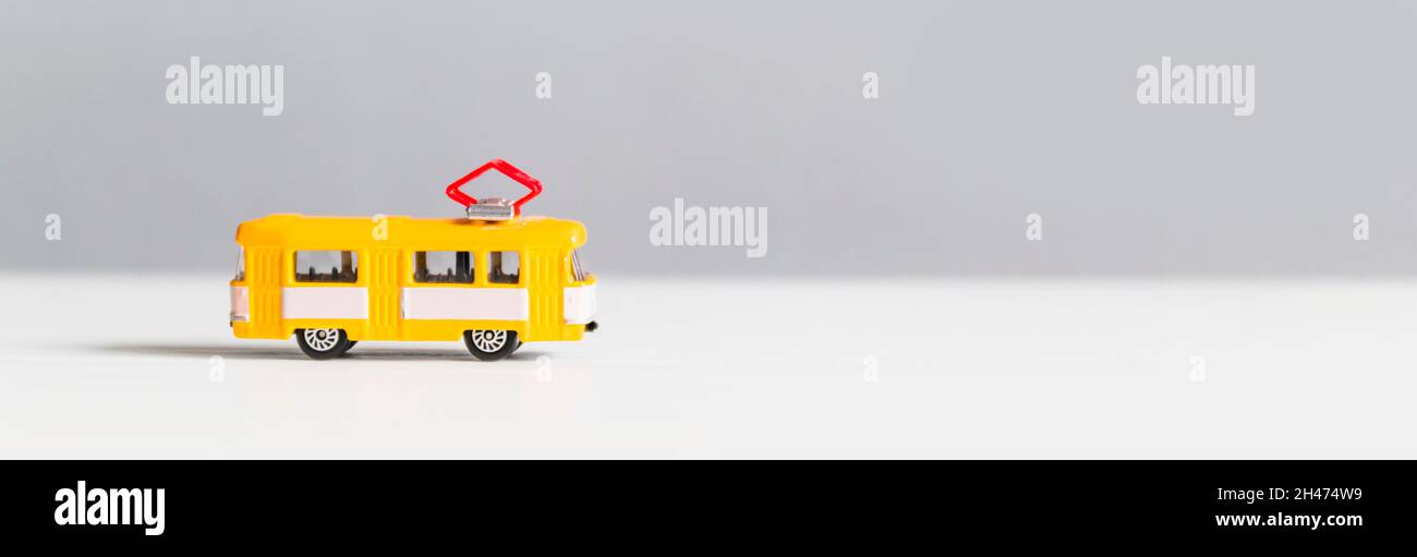 Yellow trackless trolley model toy on white gray background with copy space Stock Photo