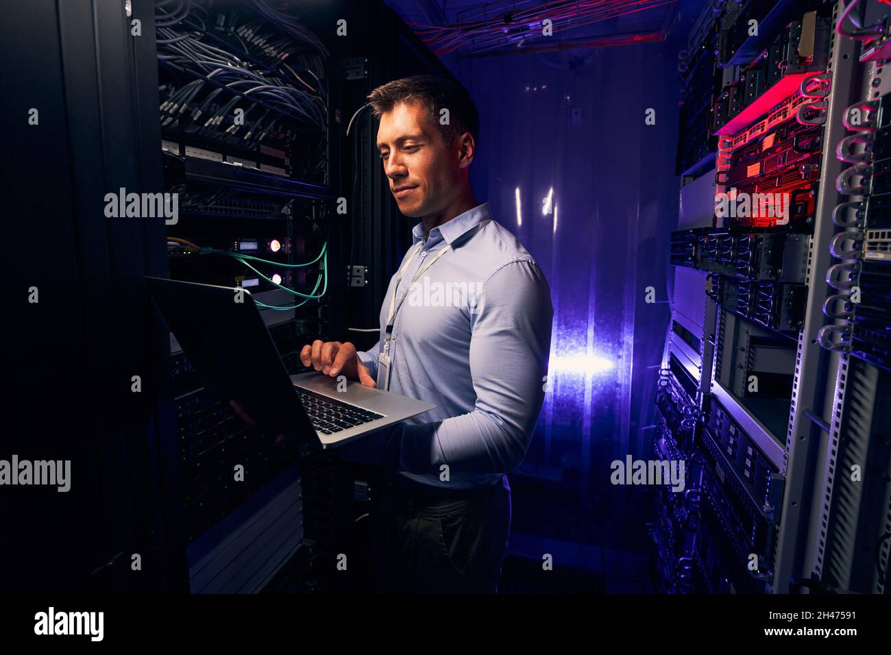 Pleased IT professional typing on his notebook computer Stock Photo