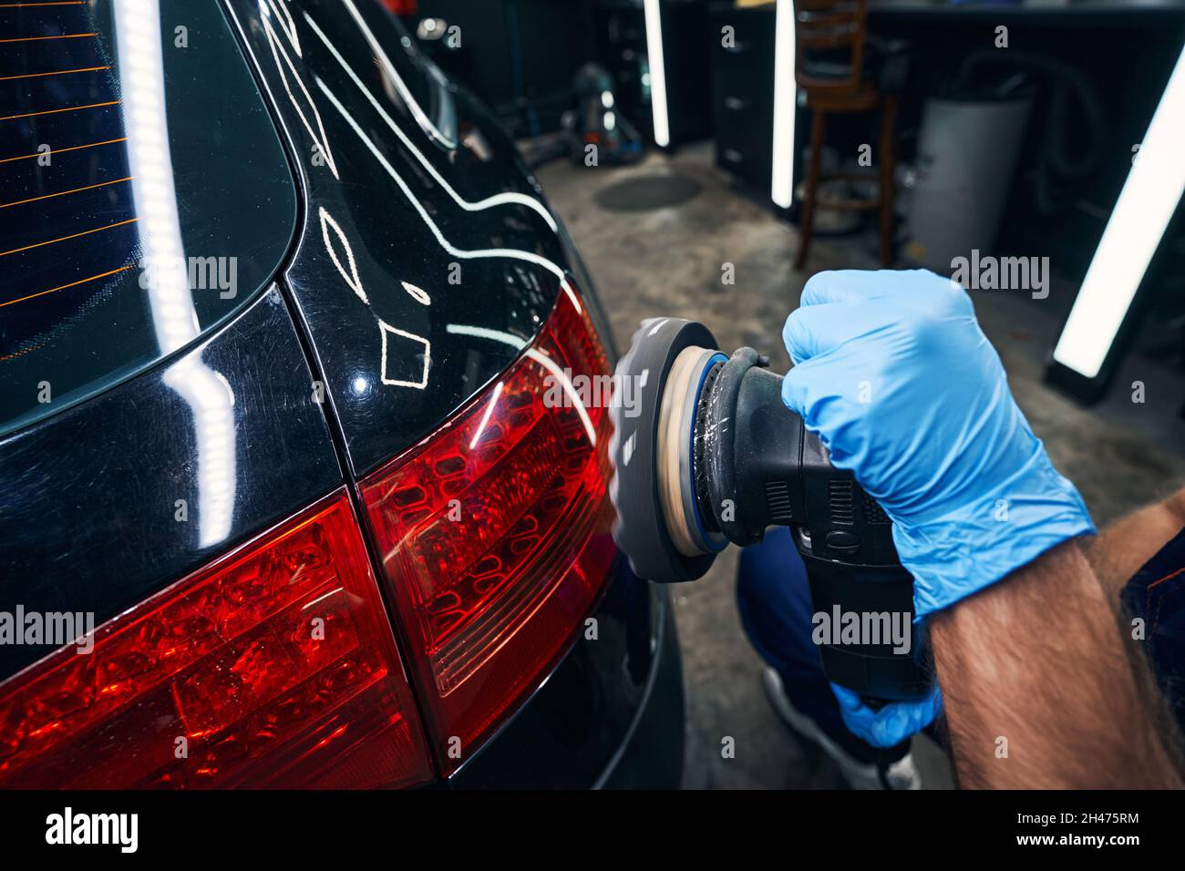 Auto mechanic polishing rear lights of car Stock Photo - Alamy