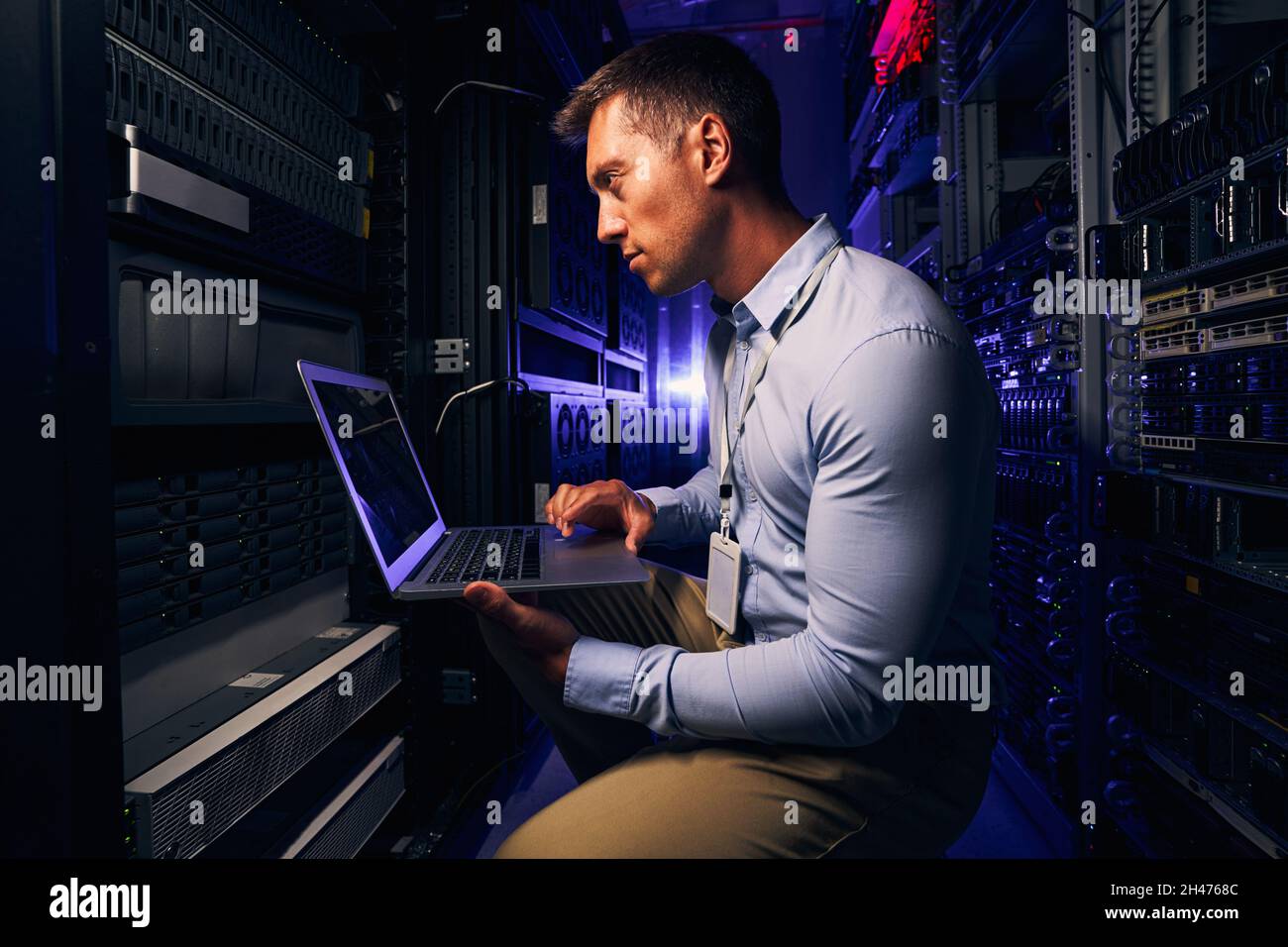 Serious focused system administrator checking data center equipment Stock Photo