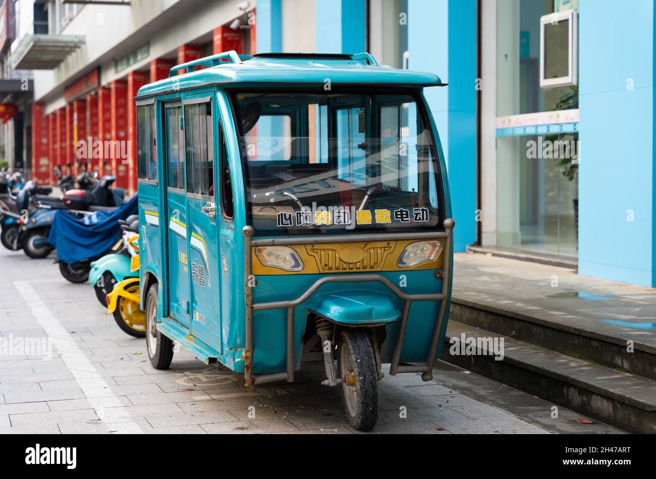 RUI'AN, WENZHOU, ZHEJIANG, CHINA - OCT 22, 2021: A tuk-tuk parked in front of a building. Stock Photo