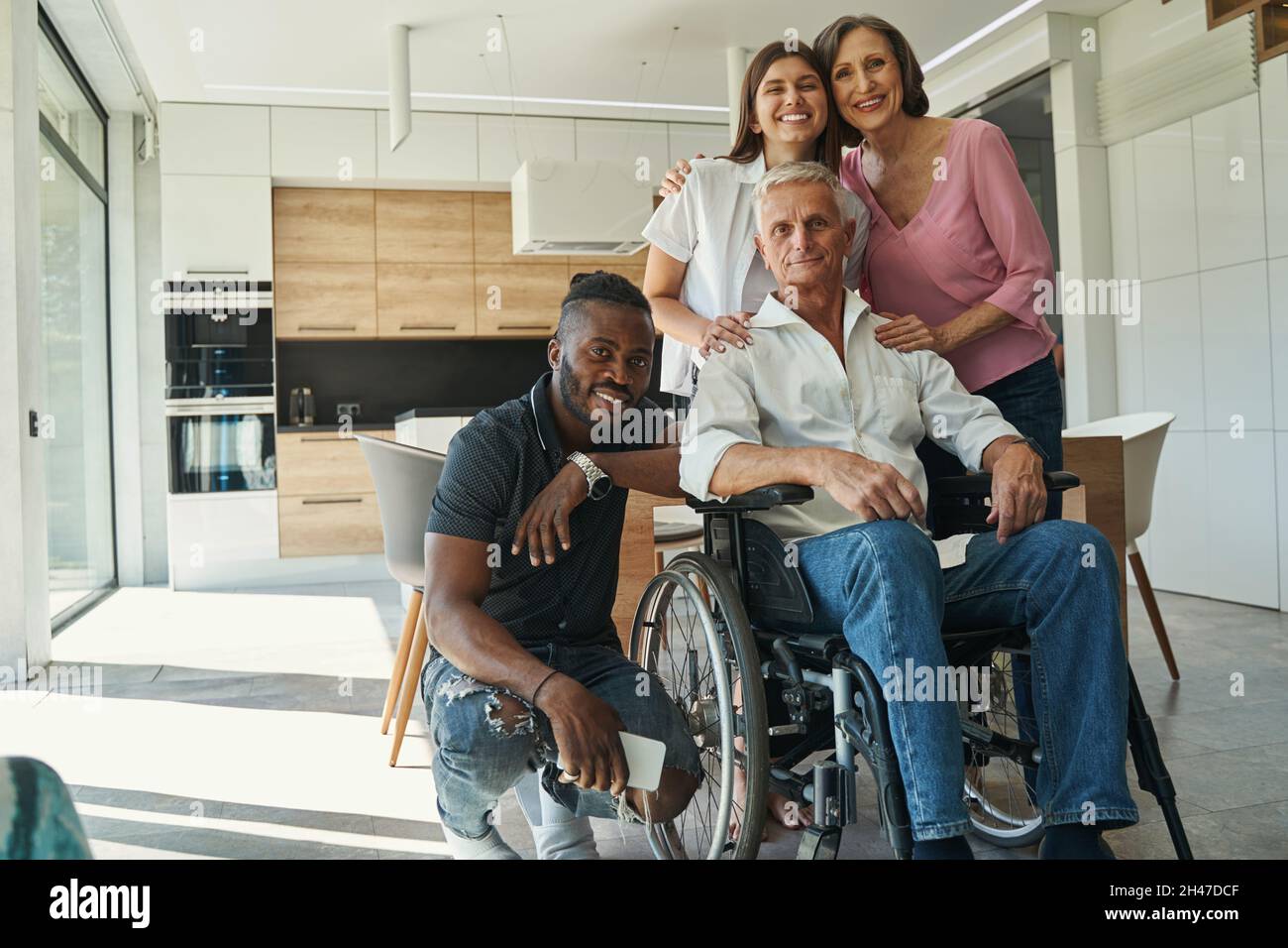 Relatives are maintaining man with physical disability Stock Photo