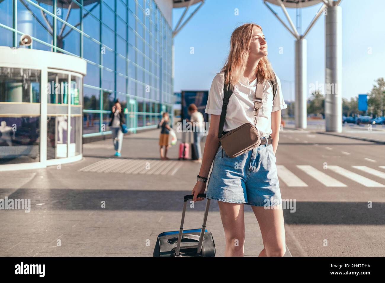 Travelwoman tourist with backpack and hand luggage suitcase standing