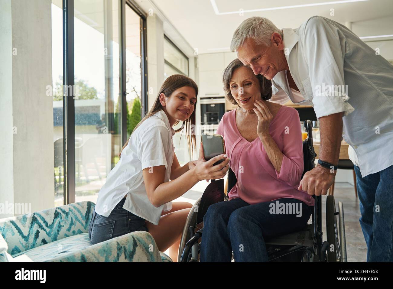 Female with disability looking at mobile with interest Stock Photo