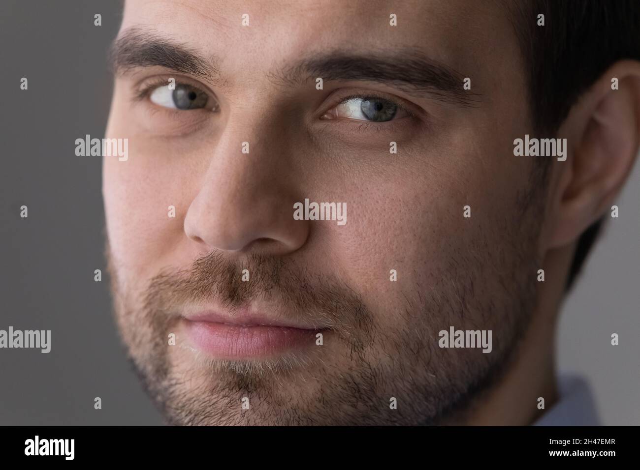 Close up handsome young man with bristle looking at camera. Stock Photo