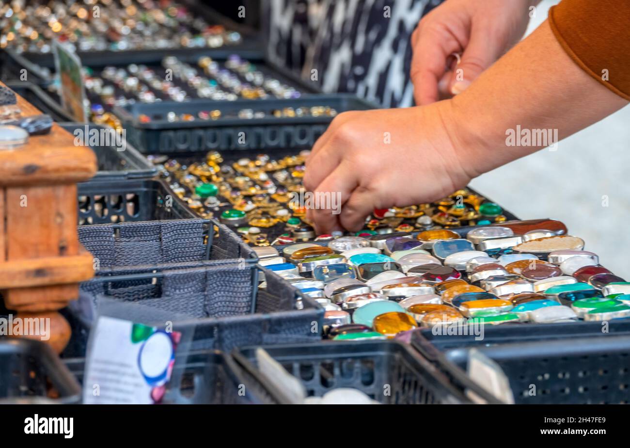 Jewelry counter at a flea market. Many different rings. Unrecognizable woman chooses a ring Stock Photo