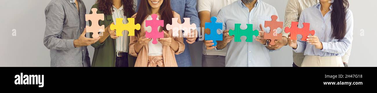 Banner background with team of happy business people joining pieces of jigsaw  puzzle Stock Photo - Alamy