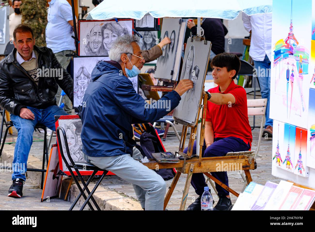 Montmartre, Paris, France - 15.07..2021: painter drawing a portrait of a kid on Place du Tertre on Montmartre district in Paris, France Stock Photo