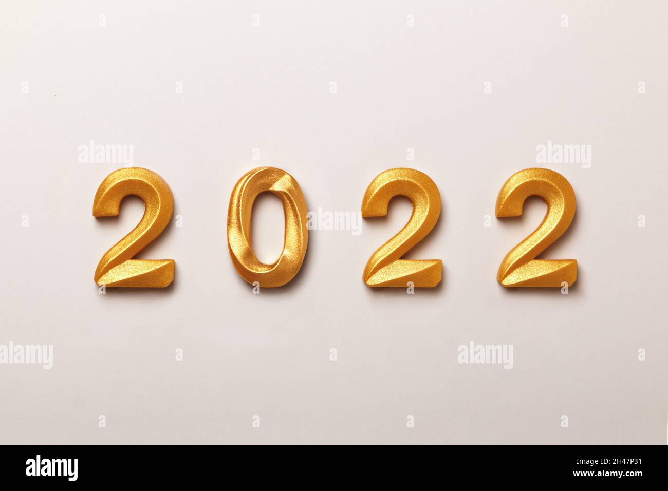 New Year composition with the inscription 2022 gold-colored numbers on a white background. Stock Photo