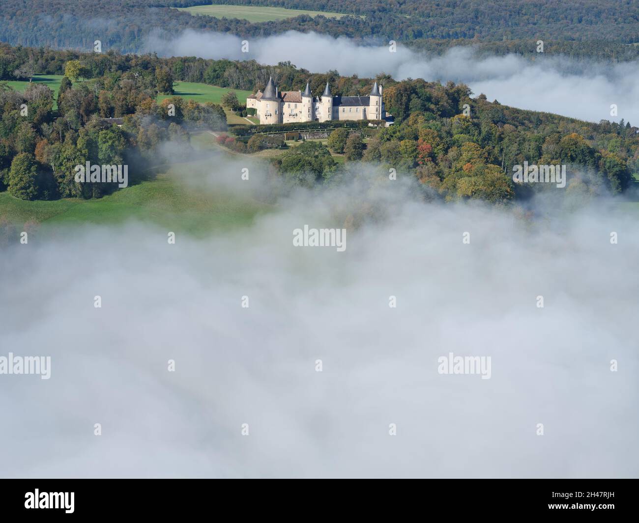 AERIAL VIEW. Medieval castle above the low-lying morning fog. Bourlemont Castle, Frebécourt, Vosges, Grand Est, France. Stock Photo