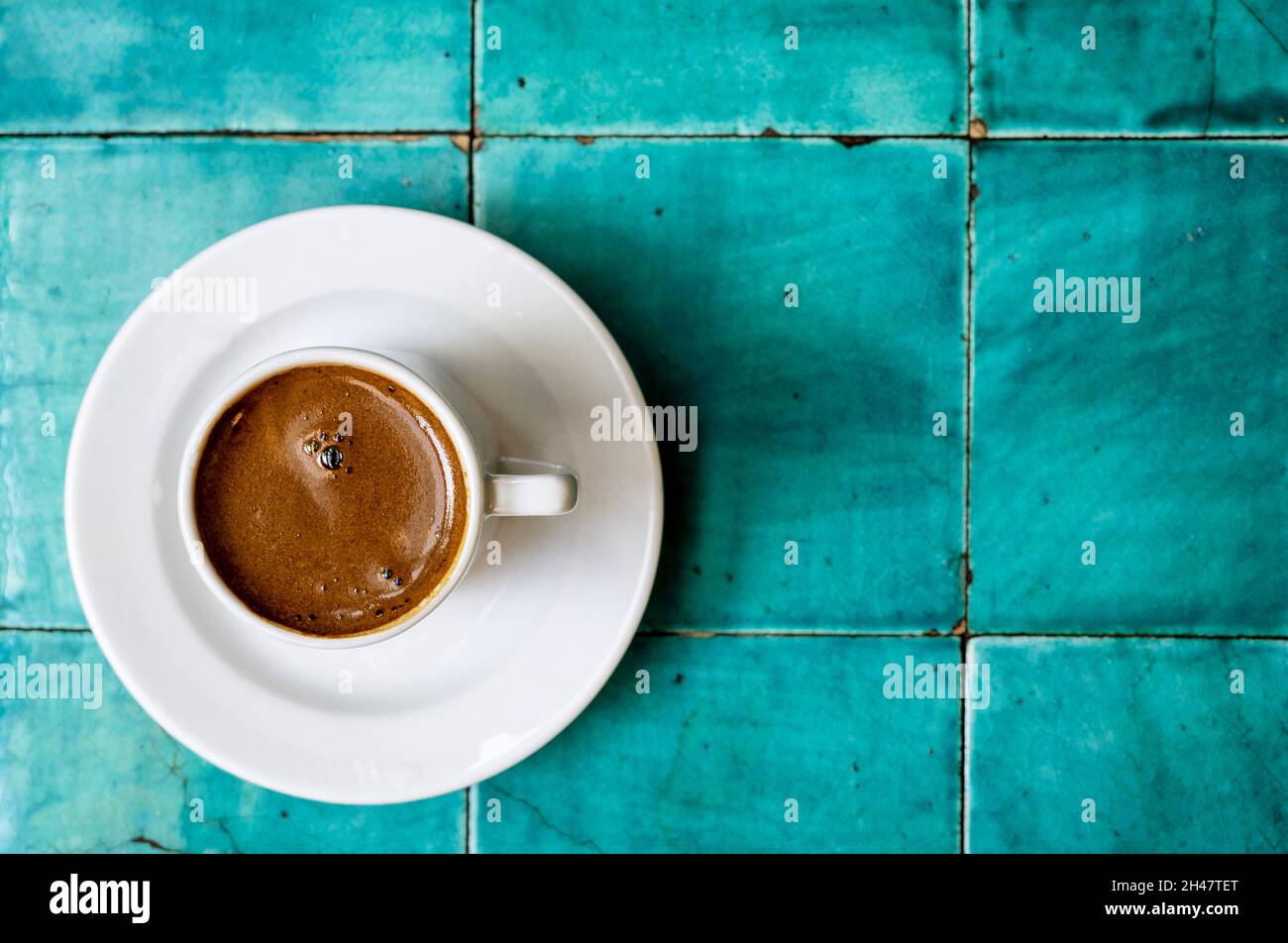 Traditional Turkish Anatolian coffee in white ceramic cup on vintage table at an old Turkish cafe Stock Photo