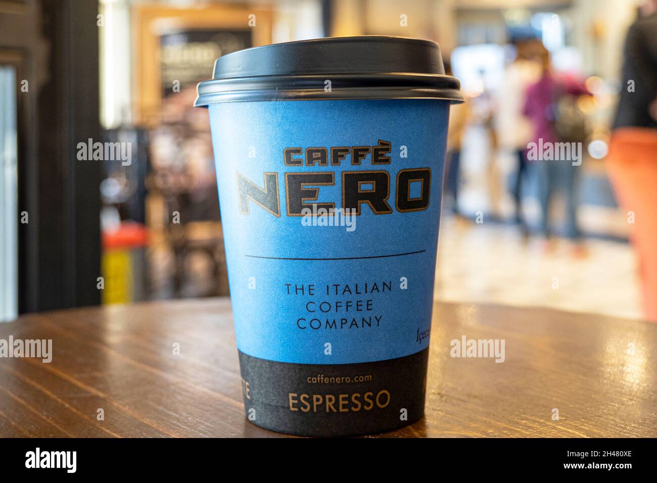 LONDON - OCT 21: Cafe Nero interior. Paper cup with Nero logotype on a table. October 21. 2021 in UK. Nero is a British coffeehouse company headquarte Stock Photo