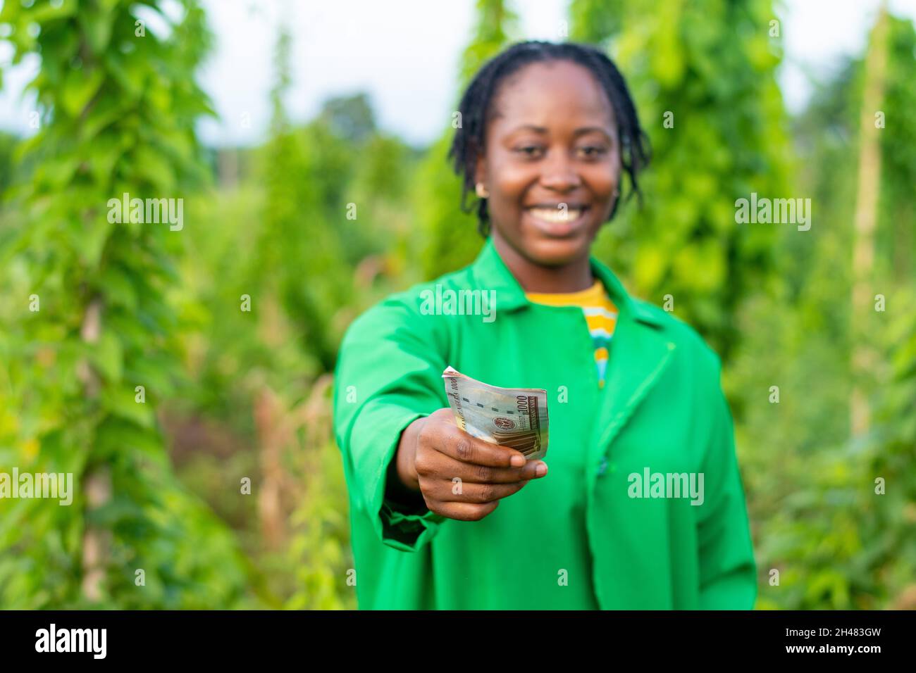Shot of a female African farmer in Nigeria stretching some money forward in  Stock Photo - Alamy