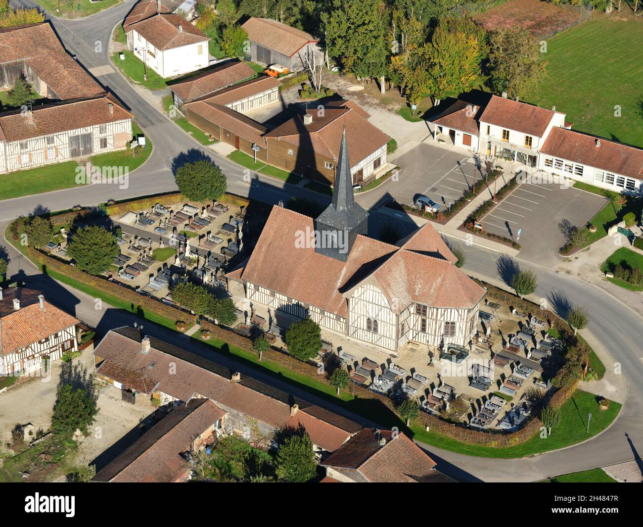 AERIAL VIEW. Historic half-timbered church surrounded by a cemetery. Outines, Aube, Grand Est, France. Stock Photo