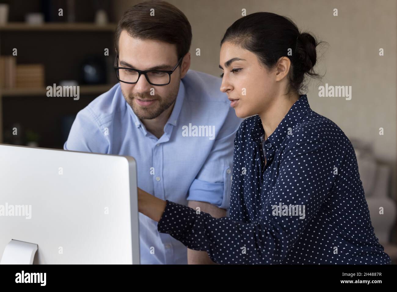 Focused millennial mixed race employees working on computer. Stock Photo