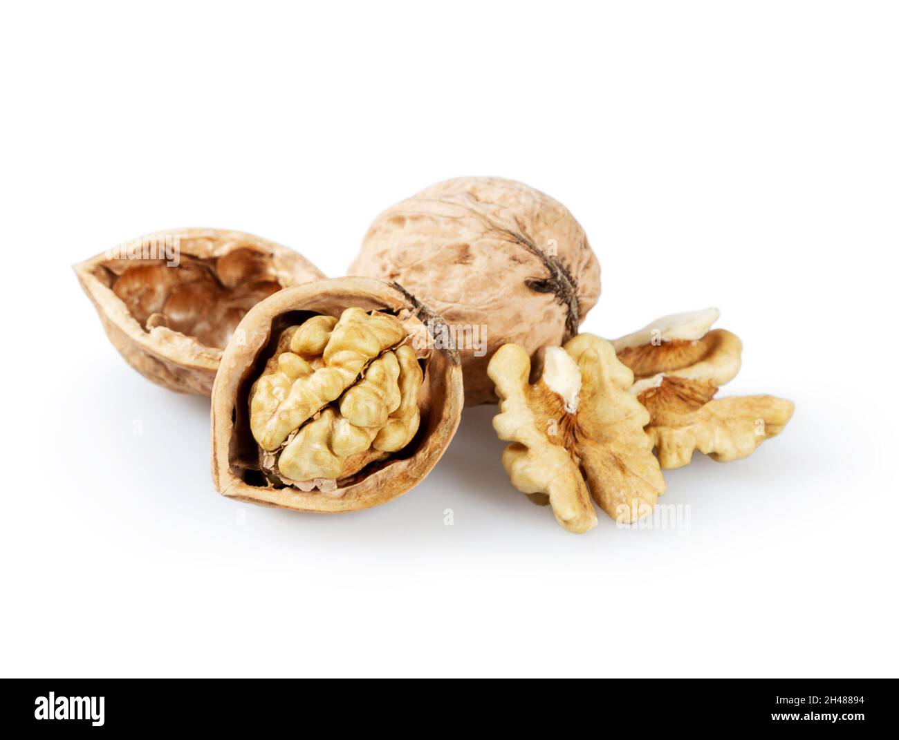 Whole and cracked walnuts on a white background. Half of walnut and
