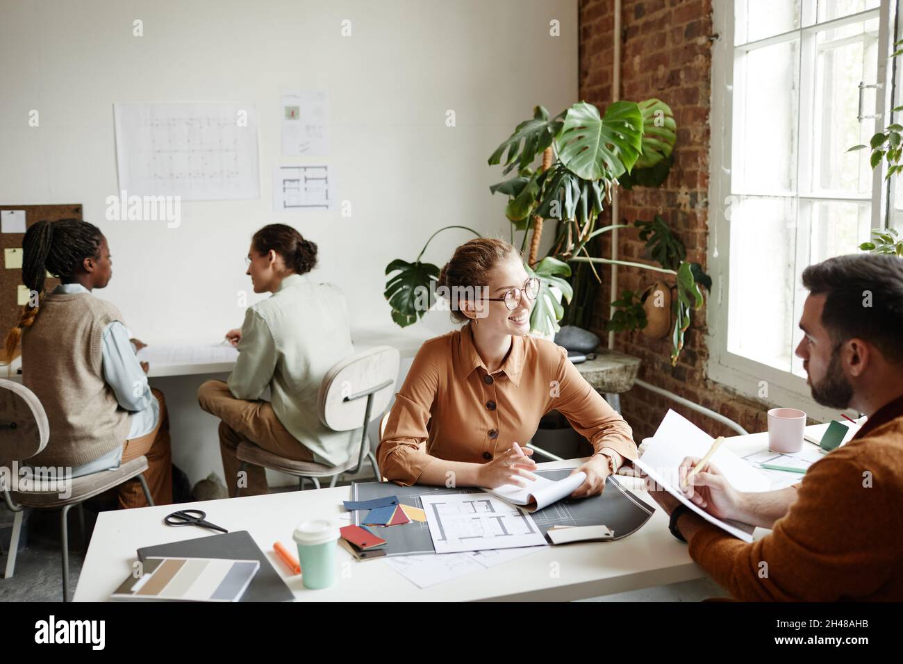 Portrait of diverse creative team working in modern studio lit by sunlight, copy space Stock Photo