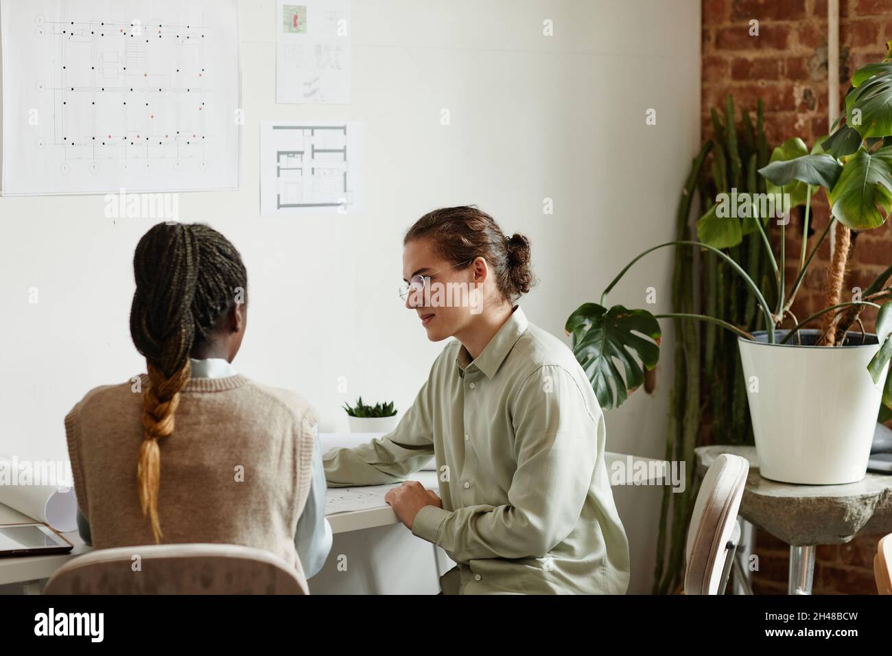 Portrait of two creative young people working on design project in minimal studio, copy space Stock Photo