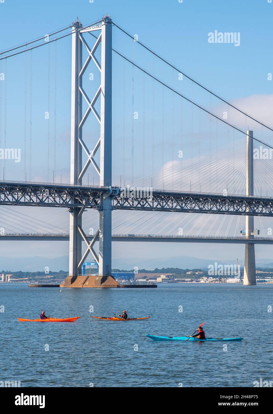 South Queensferry, Edinburgh, Scotland 7th September 2021 - Three  Kayaks passing under the Forth Road Bridges on a sunny day with clear sky. Stock Photo