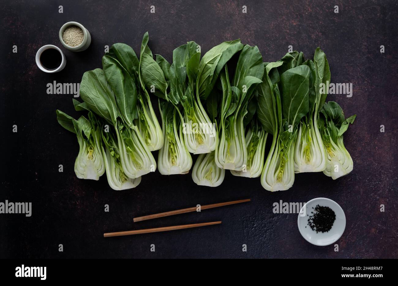 Top down view of bok choy clusters with soy sauce, sesame seeds and