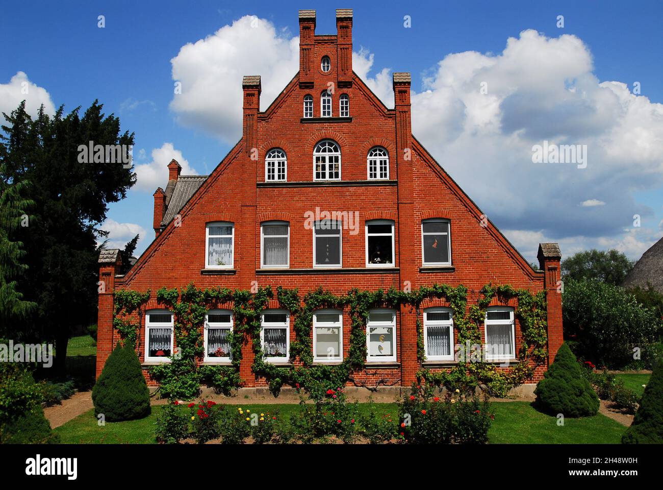 North German farmhouses with red bricks and ivy Stock Photo