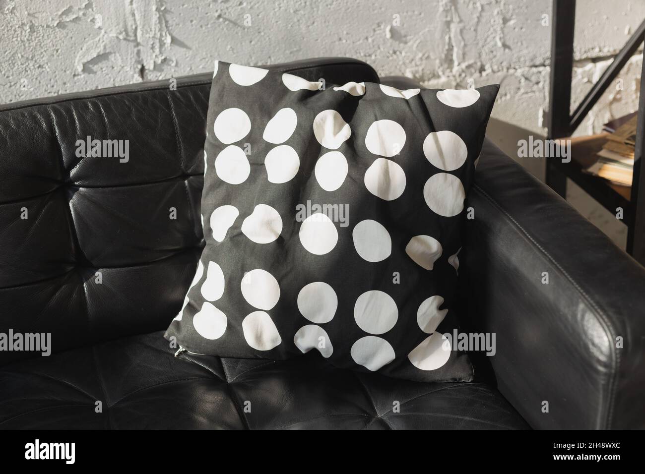 Black and white cushions on a sofa. Modern furniture. Loft interior