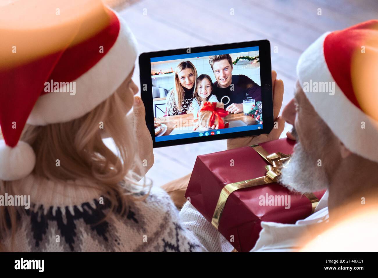 Happy grandparents old couple greeting family on Christmas video call. Stock Photo