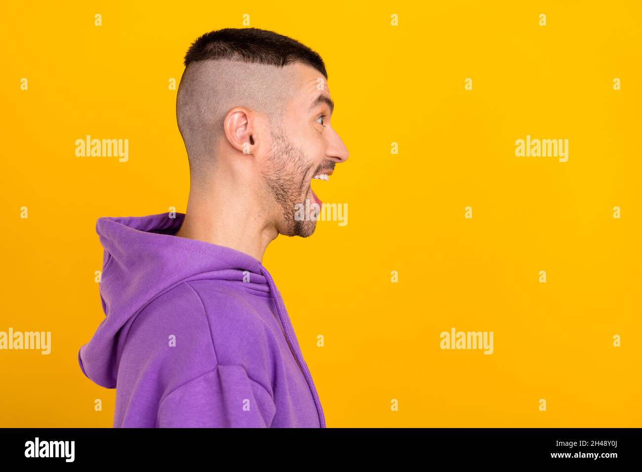 Photo portrait young man wearing purple hoody looking copyspace shouting isolated vivid yellow color background Stock Photo