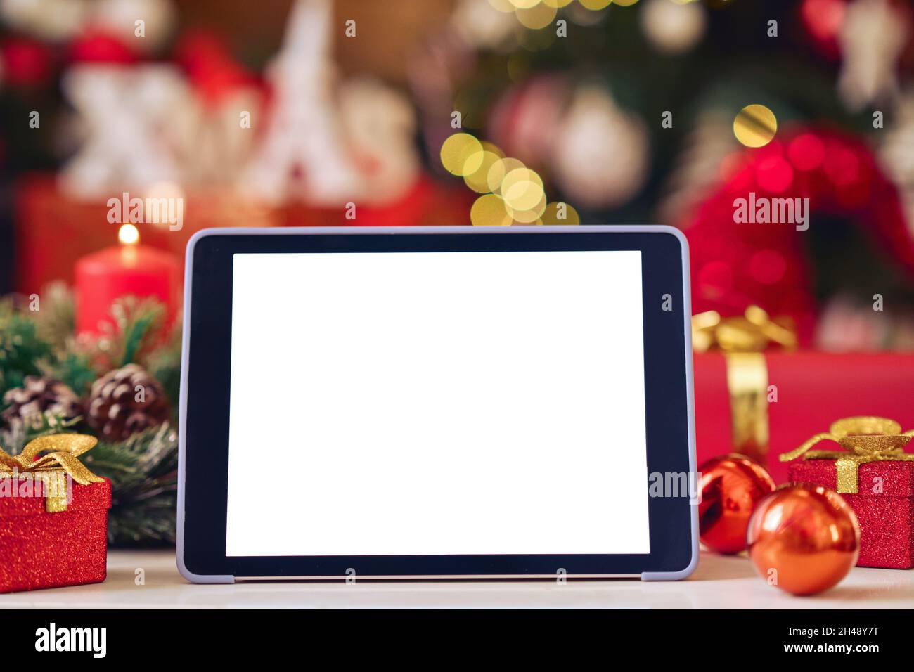 Digital tablet mockup white blank screen for ads on Christmas table background. Stock Photo