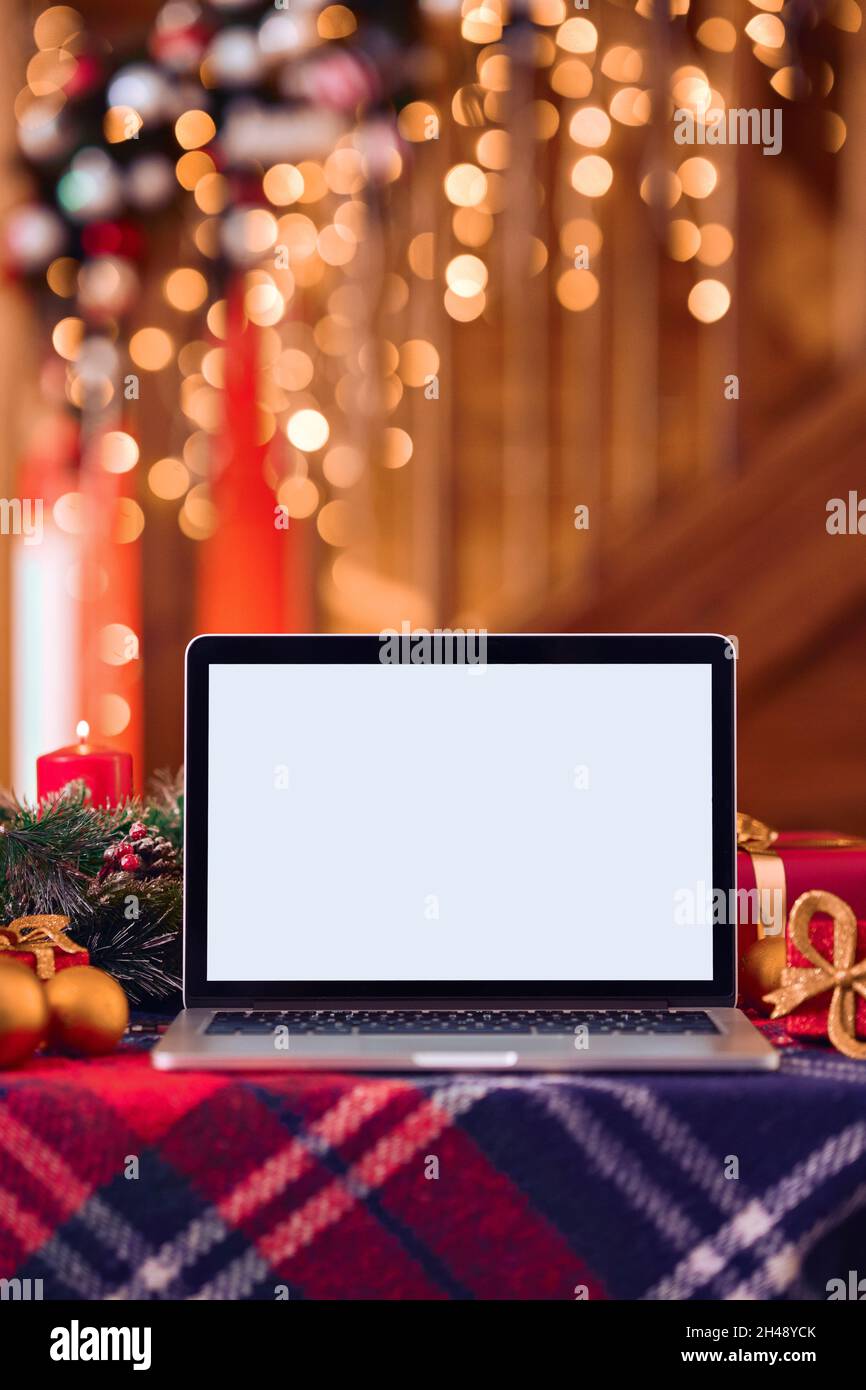Laptop computer mockup white blank screen on Christmas table background. Stock Photo