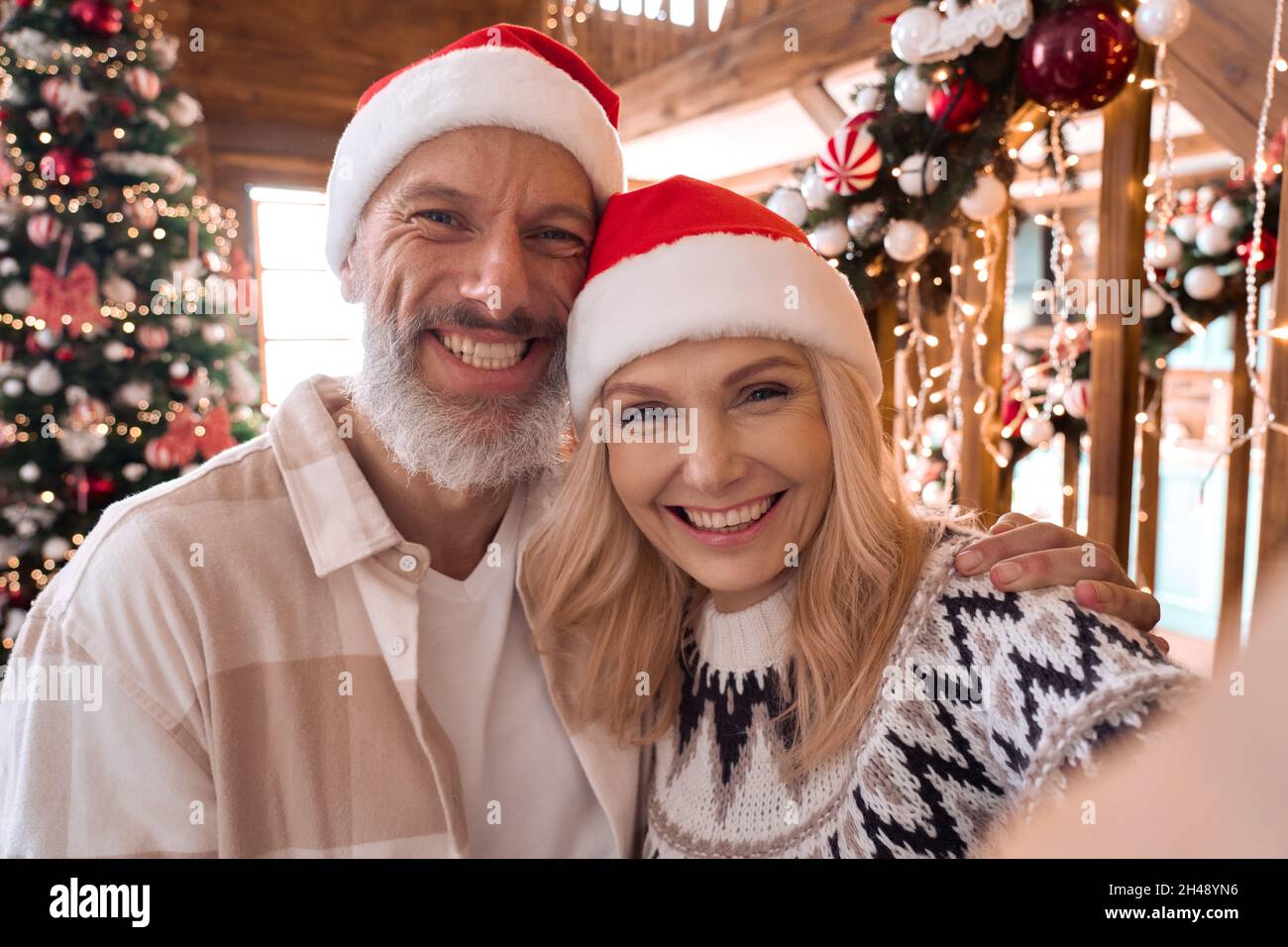 Happy older couple greeting family on Christmas video call, webcam view. Stock Photo