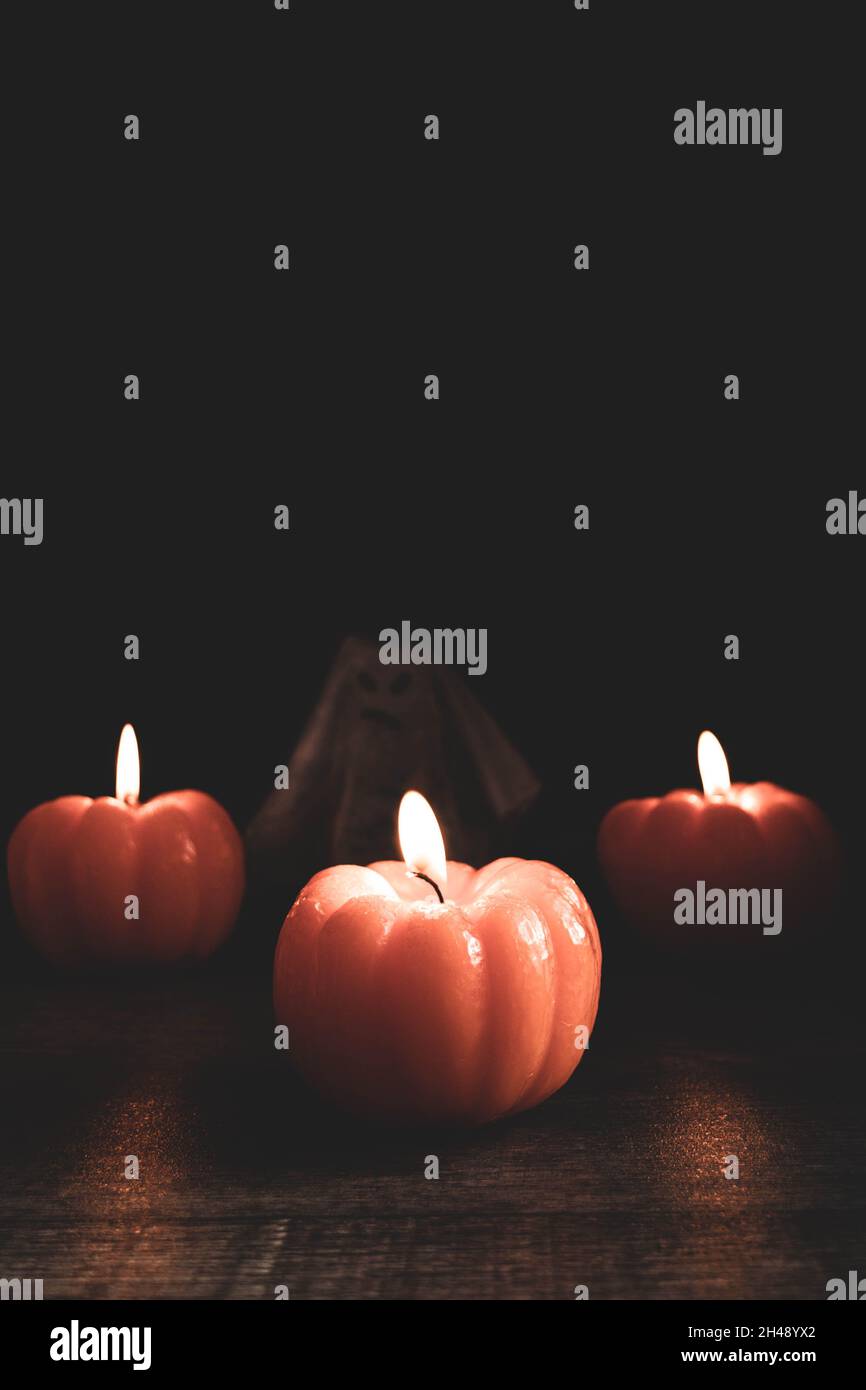 Halloween Themed Composition Of Three Lit Pumpkin shaped Candles With Halloween themed composition of three lit pumpkin shaped candles with