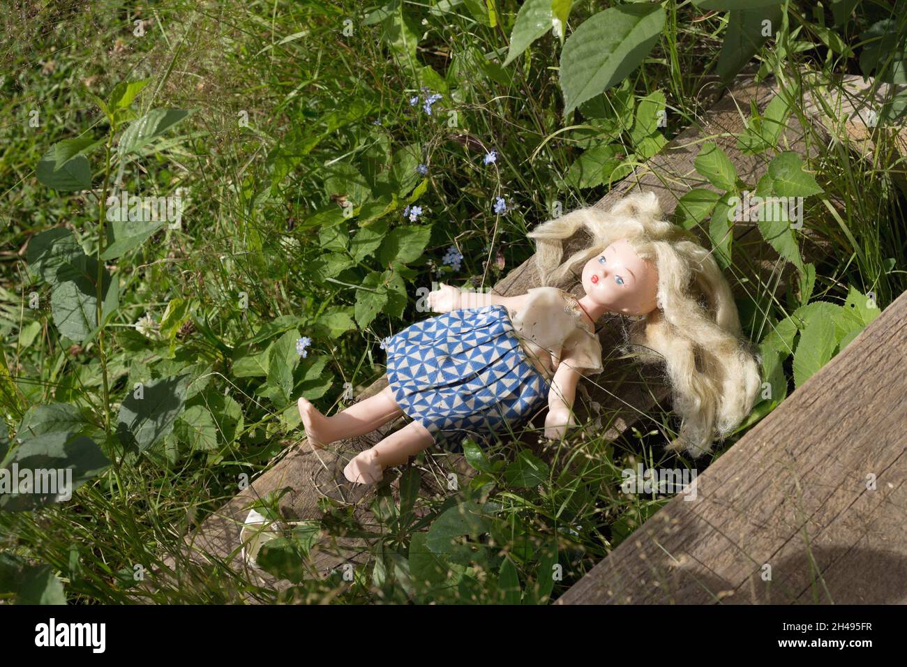 Forgotten doll in the old garden Stock Photo