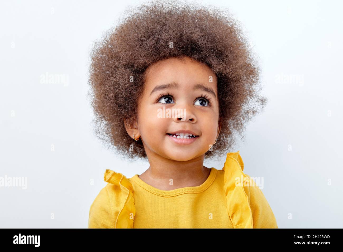 beautiful african american child with fluffy curly hair looking up and  smiling. Happy little girl isolated on white studio background with  copyspace f Stock Photo - Alamy