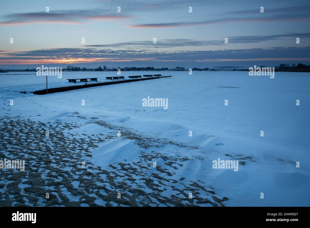 Snow on a frozen lake during sunset Stock Photo
