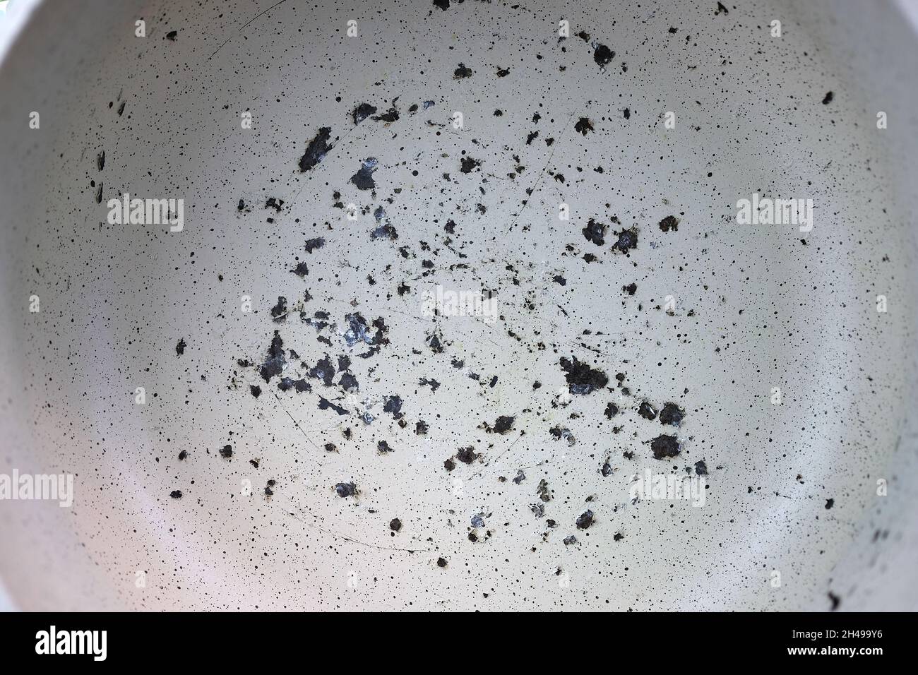 Scratched nonstick pan surface in closeup. Frying pan with an old