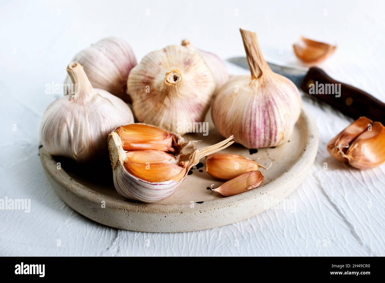 Garlic Cloves and Bulb on vintage clay plate Stock Photo - Alamy
