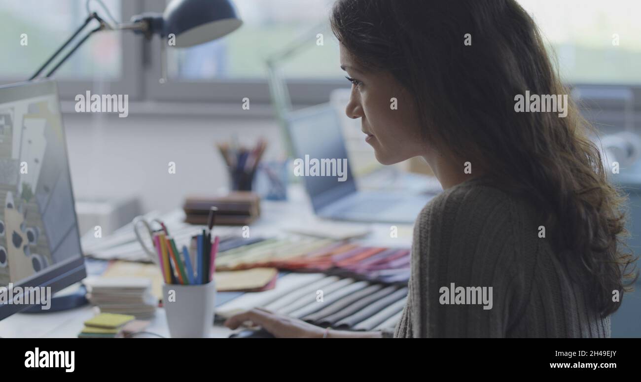 Woman sitting at desk and working on a interior design project Stock Photo